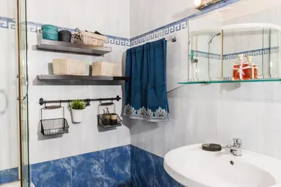 a blue and white bathroom with a sink and a shower at Zen Serenity Retreat with Great Outdoors, Pool & Parking in Áptera