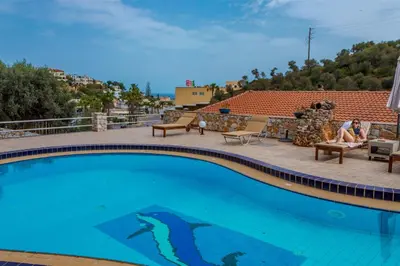 a woman sitting on a chair next to a swimming pool at Zen Serenity Retreat with Great Outdoors, Pool & Parking in Áptera