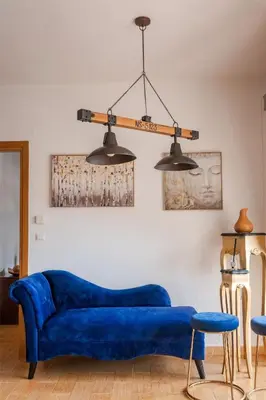 a blue couch in a living room with two lights at Zen Serenity Retreat with Great Outdoors, Pool & Parking in Áptera