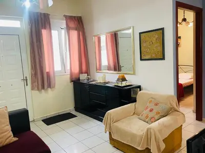 a living room with a chair and a mirror at Nea Chora cozy apartment close to the beach in Chania Town