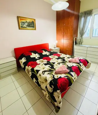 a bedroom with a bed with a floral comforter at Nea Chora cozy apartment close to the beach in Chania Town