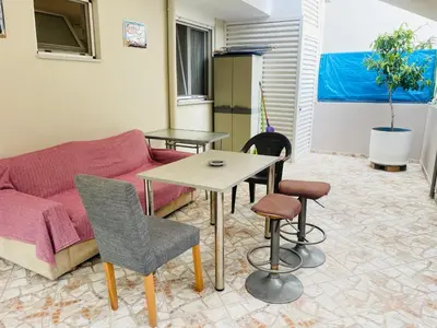a living room with a couch and a table and chairs at Nea Chora cozy apartment close to the beach in Chania Town