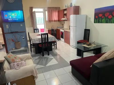 a kitchen and living room with a couch and a table at Nea Chora cozy apartment close to the beach in Chania Town