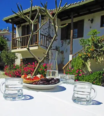a table with a plate of food and glasses of water at Diktamo House in Agia Marina Nea Kydonias