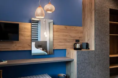 a room with a mirror and a blue wall at Ciel Collection Suites in Chania Town