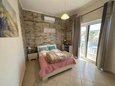 a bedroom with a bed and a brick wall at 2-Bedroom Blue & White House with Garden and Beach in Plataniás