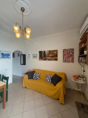 a living room with a yellow couch in a room at 2-Bedroom Blue & White House with Garden and Beach in Plataniás