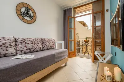 a living room with a couch and a clock on the wall at Vereniki Suites Chania in Chania Town