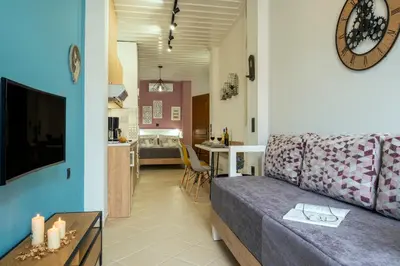 a living room with a couch and a kitchen at Vereniki Suites Chania in Chania Town