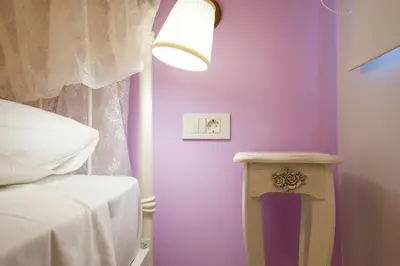 a bedroom with purple walls and a bed and a table at Gina's home in Kolymvari