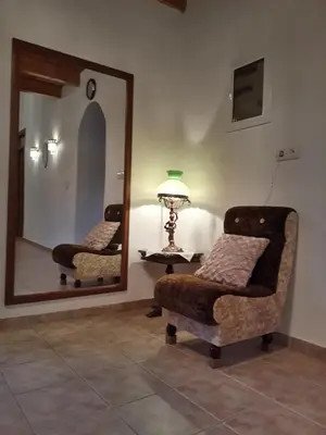 a living room with a chair and a mirror at Hidden House in Nature in Zounákion