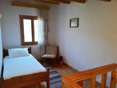 a small bedroom with a bed and a window at Hidden House in Nature in Zounákion