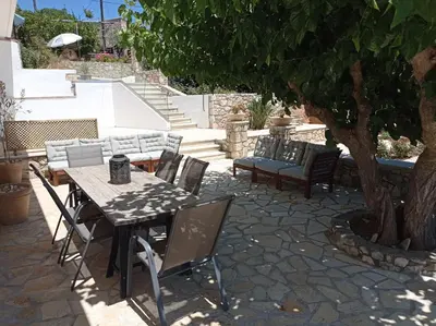 a patio with a table and chairs under a tree at PALACE Mountain view in Megála Khoráfia