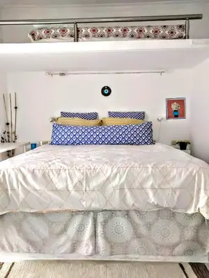 a bedroom with a white bed with blue and white pillows at Zamboli in Chania Town