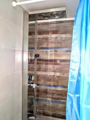 a bathroom with a shower with a wooden wall at Zamboli in Chania Town