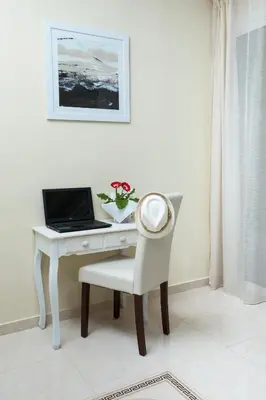 a white desk with a laptop and a chair at Georgia Sunset in Trákhilos