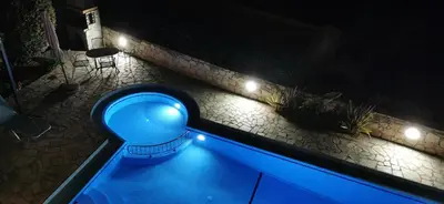 a blue swimming pool at night with lights at Villa Koumos - Crete Holidays With Pool and Views in Gavalochori