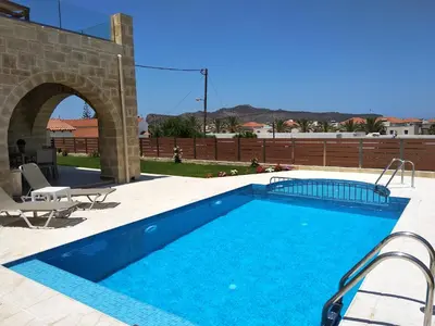 a large swimming pool in a yard with a patio at Villa Katerina in Agia Marina Nea Kydonias