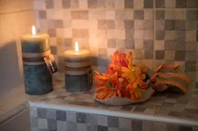 two candles and a vase with flowers on a counter at Villa Katerina in Agia Marina Nea Kydonias