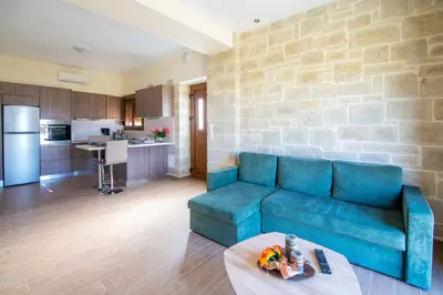 a living room with a blue couch and a kitchen at Villa Katerina in Agia Marina Nea Kydonias