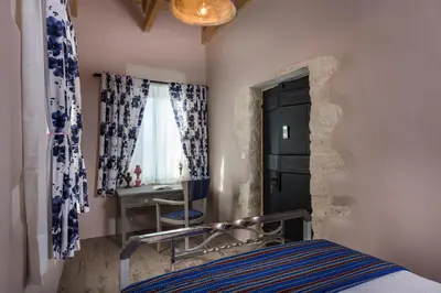 a bedroom with a bed and a desk and a chair at Boutique Villa Kalliope in Gavalochori
