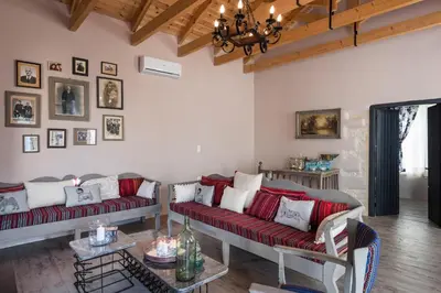 a living room with two red couches and a table at Boutique Villa Kalliope in Gavalochori