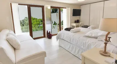 a white bedroom with two beds and a couch at Villa Evangelia in Chania Town