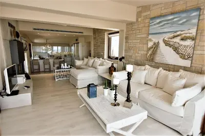 a living room with white furniture and a brick wall at Villa Evangelia in Chania Town