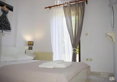 a bedroom with a white bed and a window at Chania Lissosaparments in Kato Daratso