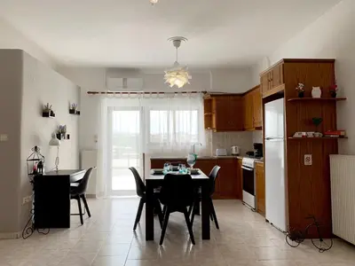 a kitchen with a table and chairs in a kitchen at Chania Lissosaparments in Kato Daratso