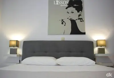 a bedroom with a bed with a painting above it at Chania Lissosaparments in Kato Daratso