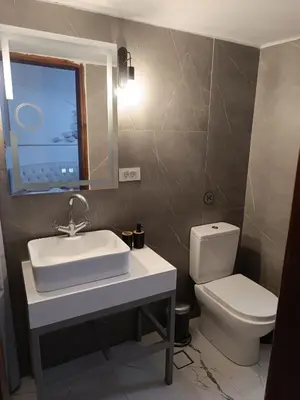 a bathroom with a sink and a toilet and a mirror at PALACE Sea view in Megála Khoráfia