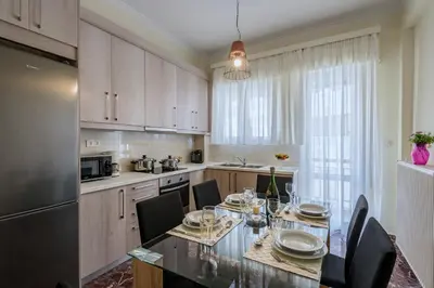 a kitchen with a dining table with chairs and a refrigerator at Aspasias Luxury Suite in Chania Town