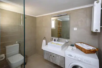 a bathroom with a sink and a washing machine at Aspasias Luxury Suite in Chania Town