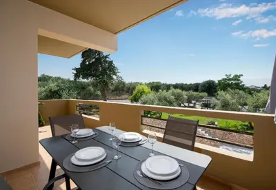 a dining table on the balcony of a house at Valia's House in Kato Daratso