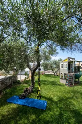 a swing hanging from a tree in a yard at Valia's House in Kato Daratso