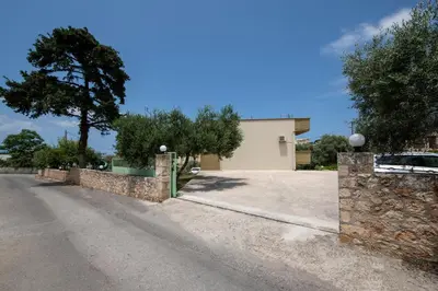 a driveway with a stone wall and a garage at Valia's House in Kato Daratso
