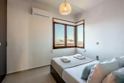 a white room with a bed and a window at Soleado apartment in Chania Town