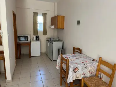 a small kitchen with a table and a microwave at Mediterranean Sea Down Floor in Palaiochóra