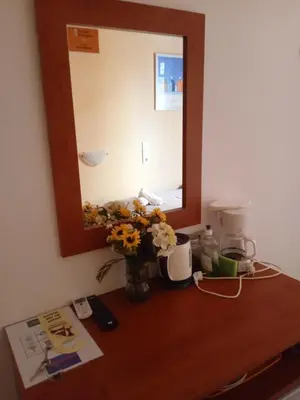 a table with a mirror and a vase of flowers on it at Smaragdi in Chania Town