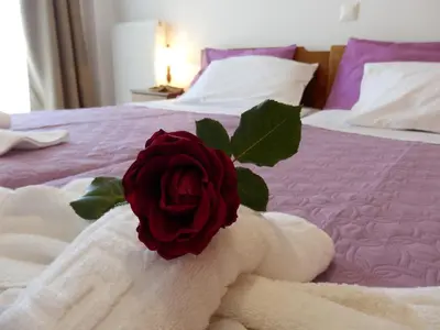 a red rose sitting on top of a bed at Charisma Apartment in Plataniás