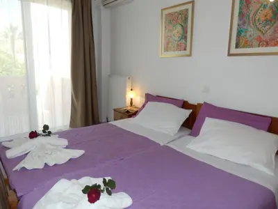 a bedroom with a purple bed with towels on it at Charisma Apartment in Plataniás