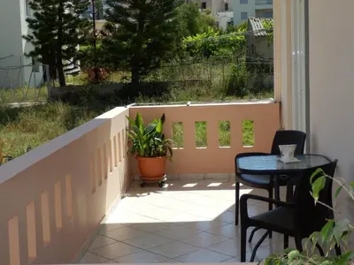a patio with a table and chairs and a fence at Charisma Apartment in Plataniás