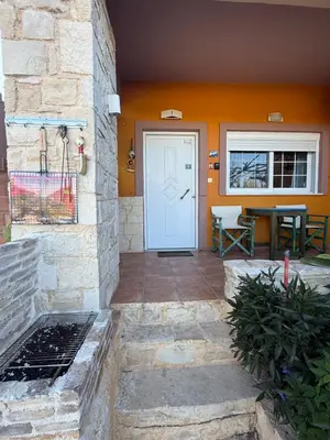 a house with a white door and a table at Modern 1-bedroom with BBQ & Roof Garden near Beach in Stalos