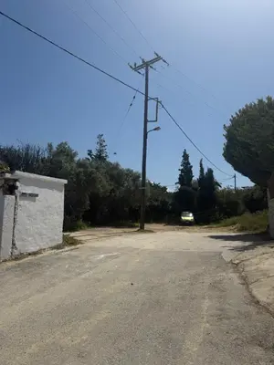 an empty road with a telephone pole and a car at Modern 1-bedroom with BBQ & Roof Garden near Beach in Stalos