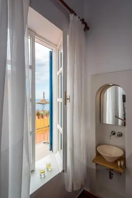 a bathroom with a sink and a window at Hotel Amphora in Chania Town