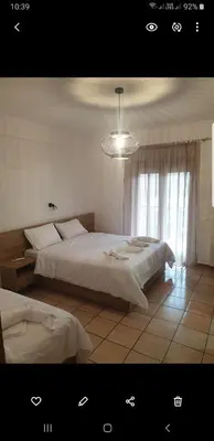 a bedroom with two beds and a chandelier at To Ellinikon in Omalós