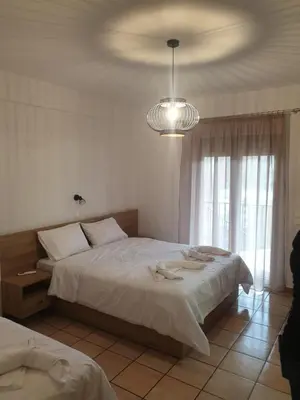 a bedroom with a large bed and a chandelier at To Ellinikon in Omalós