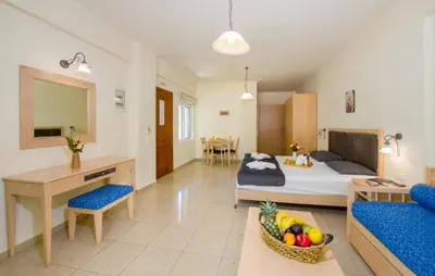 a bedroom with a bed and a desk and a table at Toxo Hotel in Plataniás