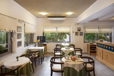a restaurant with tables and chairs in a room at Rea Hotel in Palaiochóra
